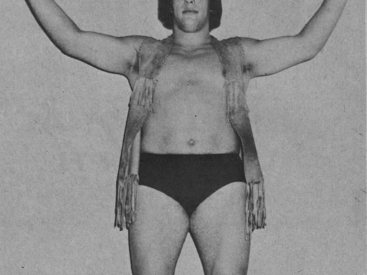 Andre the Giant posing in 1973 with his curly hair and enormous frame