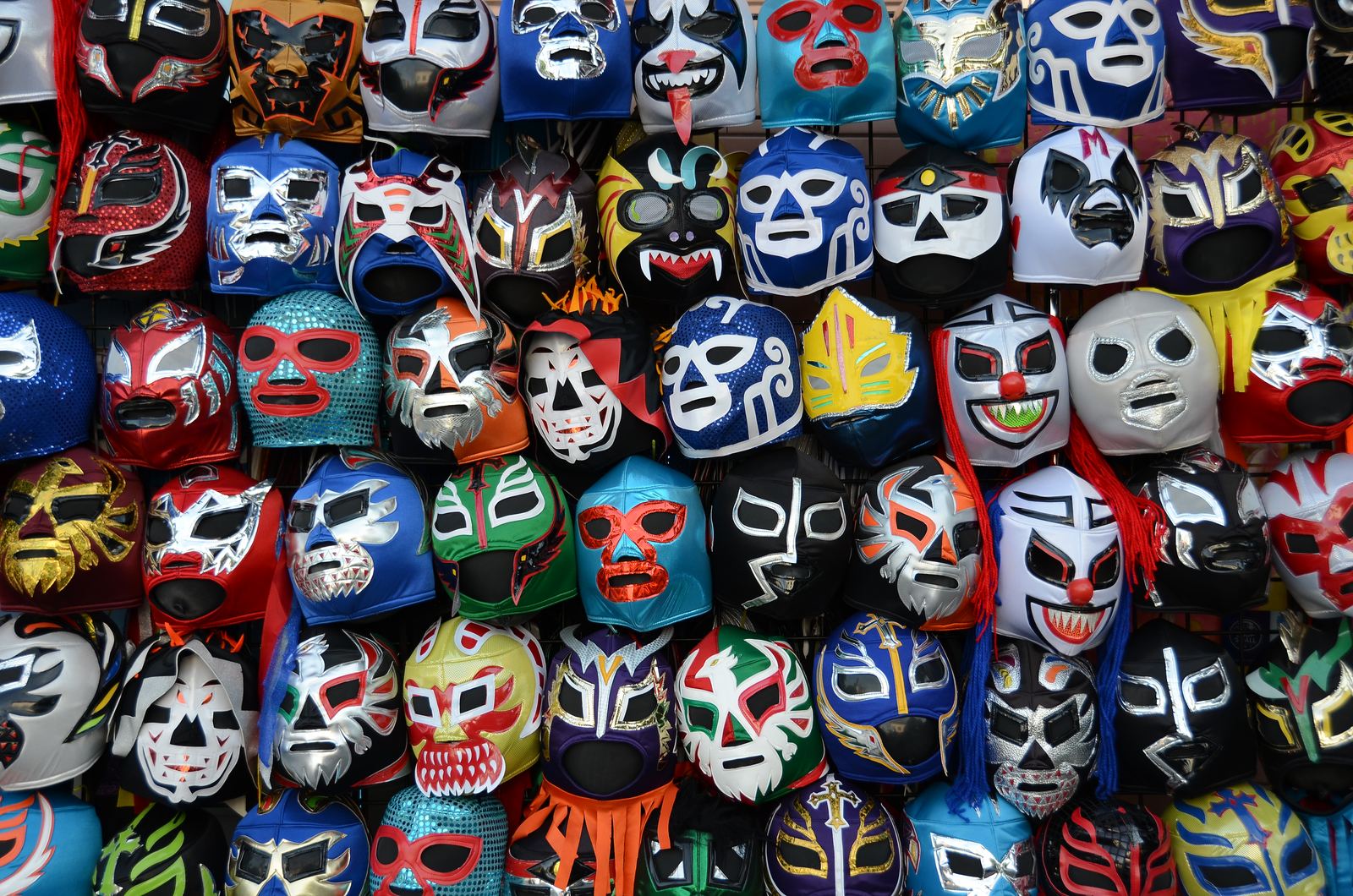 Rows of colorful Mexican lucha libre wrestling masks hanging for sale