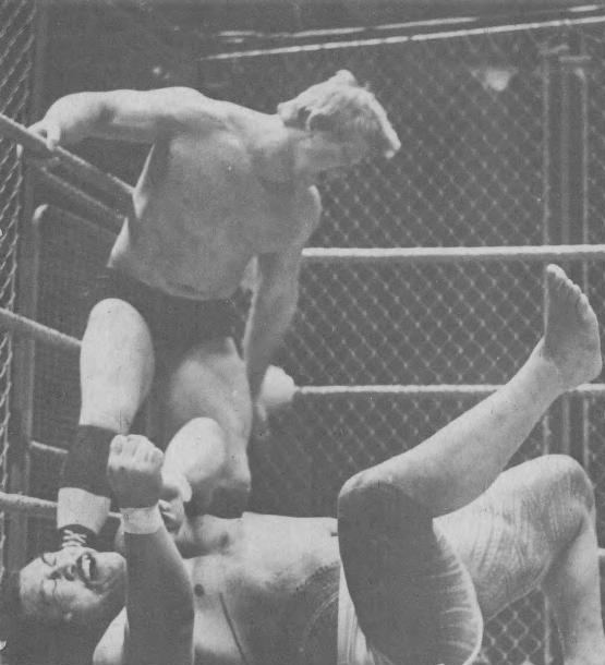Bob Backlund kicking Peter Maivia inside a steel cage in 1979