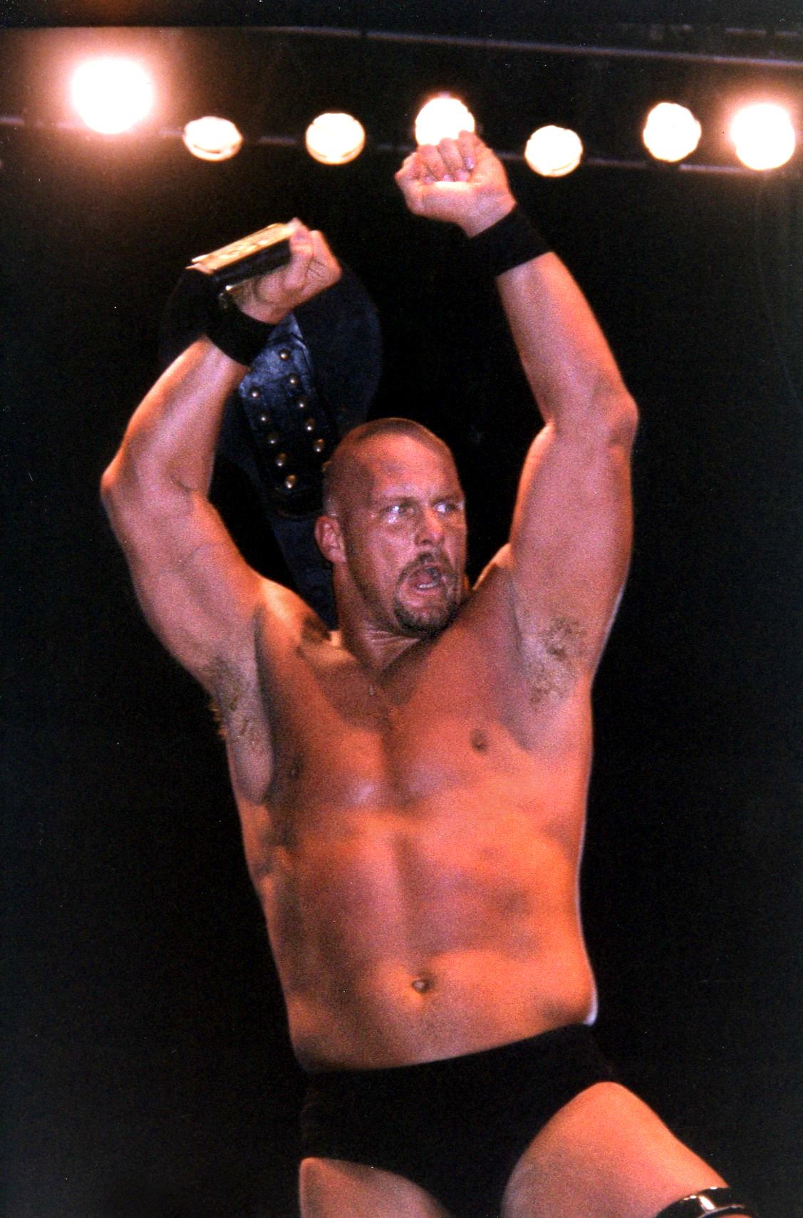 Stone Cold Steve Austin in his vest holding the WWF Championship belt